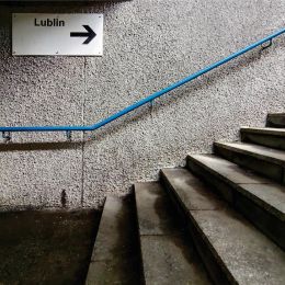 Schody, na ścianie tabliczka z napisem "Lublin"