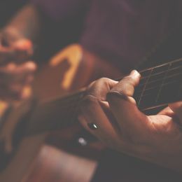 Zbliżenie na dłonie grające na gitarze